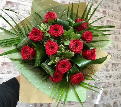 An eco recycled glass vase arrangement of 12 High Quality hand tied Naomi Red Roses.