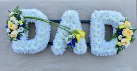 DAD tribute based in white flowers with yellow, blue and white floral sprays.