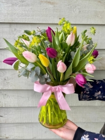 20 beautiful mixed tulips hand tied in a tinted coloured vase.